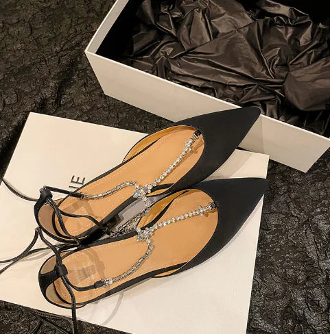 Detailed image of black Mary Jane flats emphasizing pearl ornamentation and craftsmanship