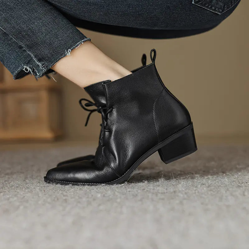 Stylish pointed-toe lace-up boots with chunky heels made from high-quality cowhide leather for a bold, fashionable look