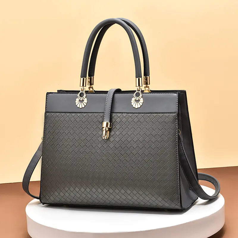 Elegant grey women's handbag featuring spacious interior and chic lace and leather accents