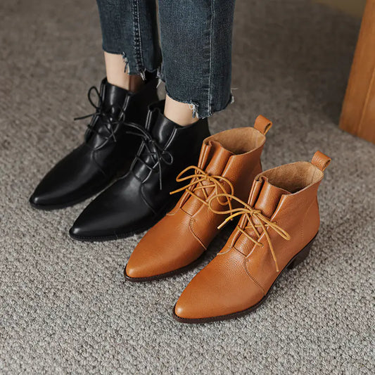 A stylish pair of pointed-toe lace-up chunky heel boots crafted from high-quality cowhide leather, featuring a sleek design with a pointed toe and lace-up front, perfect for fashionable outfits and outdoor wear