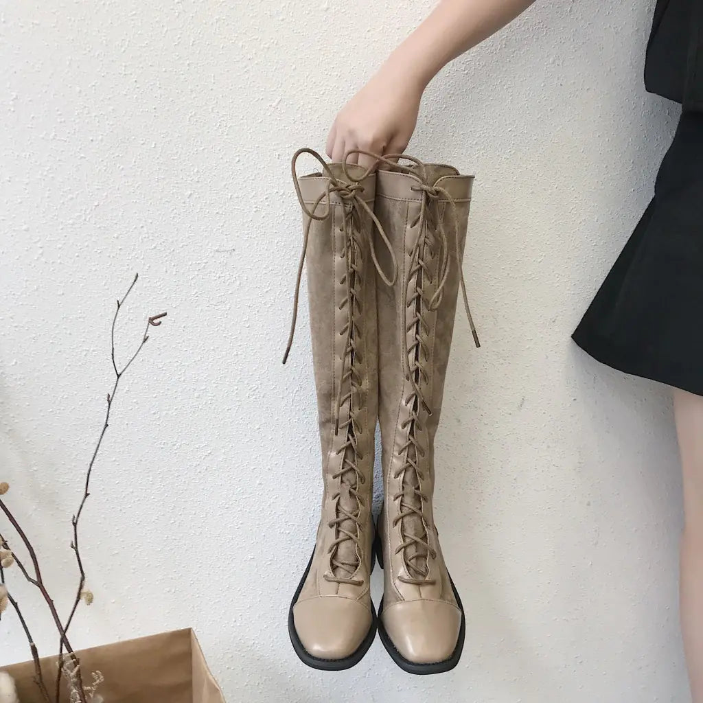 A stylish pair of chunky heel knee-high boots featuring a sleek design and sturdy platform for comfortable, fashionable wear
