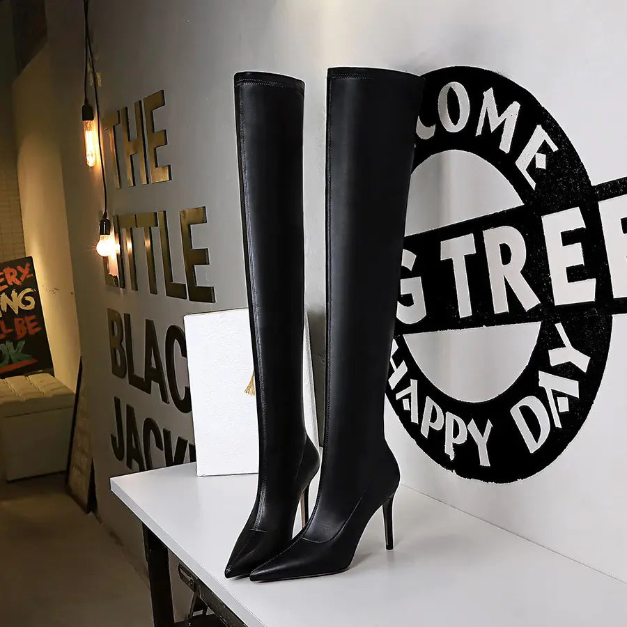 Fashionable black over-the-knee boots with a smooth finish and pointed toe detail